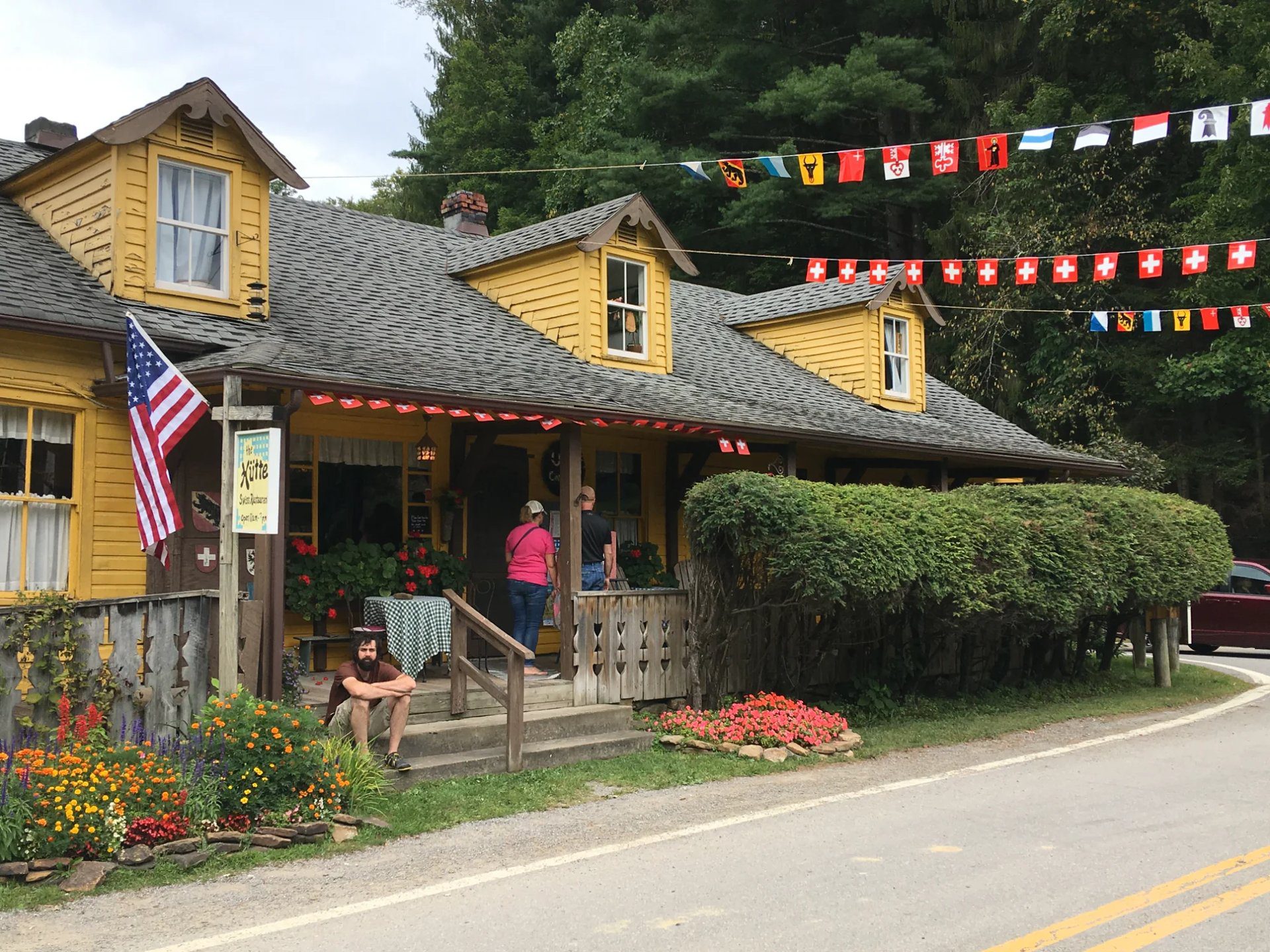 Yellow building decorated with Swiss and United states flags during Helvetia Community Fair